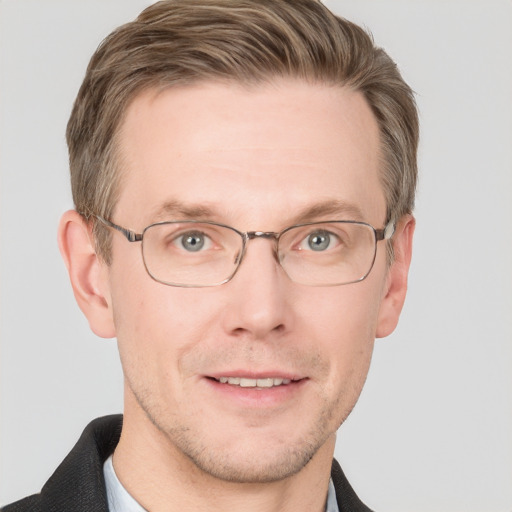 Joyful white adult male with short  brown hair and blue eyes