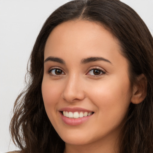 Joyful white young-adult female with long  brown hair and brown eyes