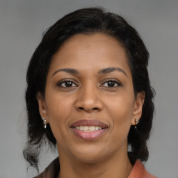 Joyful black adult female with medium  brown hair and brown eyes