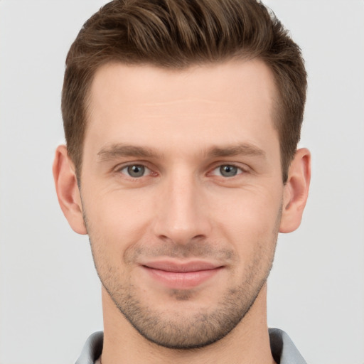 Joyful white young-adult male with short  brown hair and grey eyes