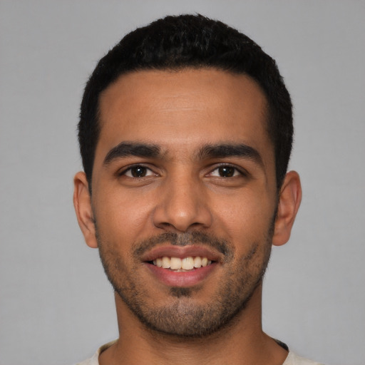 Joyful latino young-adult male with short  black hair and brown eyes