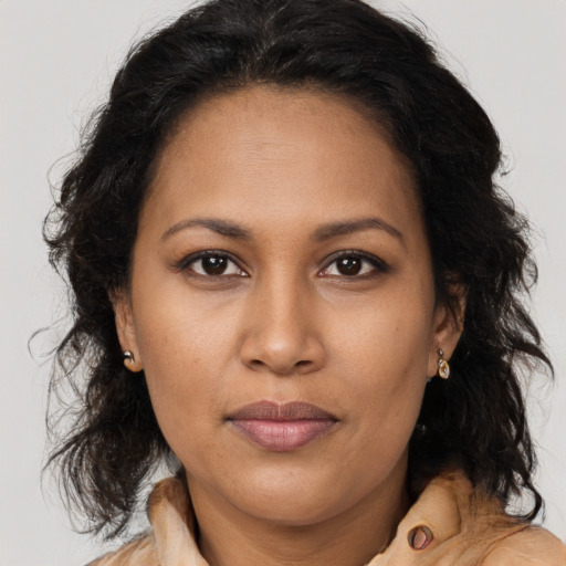 Joyful black adult female with long  brown hair and brown eyes