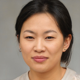 Joyful asian adult female with medium  brown hair and brown eyes