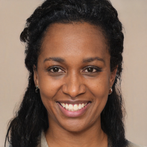 Joyful black adult female with long  black hair and brown eyes