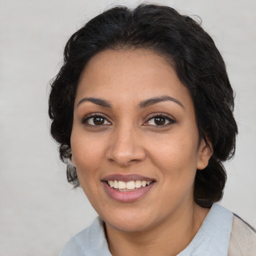 Joyful latino adult female with medium  brown hair and brown eyes