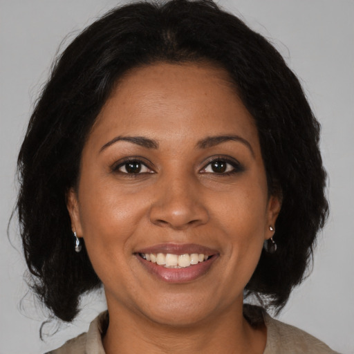 Joyful black adult female with medium  brown hair and brown eyes