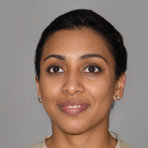 Joyful black young-adult female with short  black hair and brown eyes