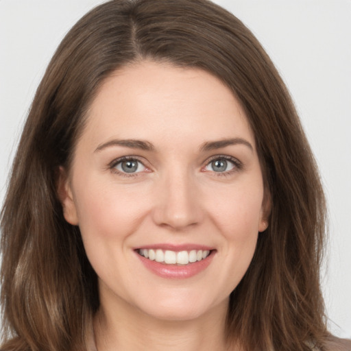 Joyful white young-adult female with long  brown hair and grey eyes