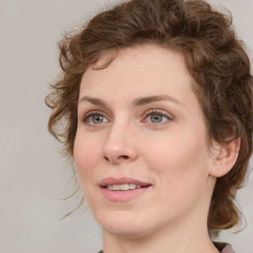 Joyful white young-adult female with medium  brown hair and green eyes