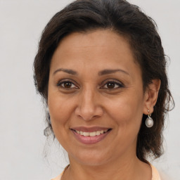 Joyful latino adult female with medium  brown hair and brown eyes