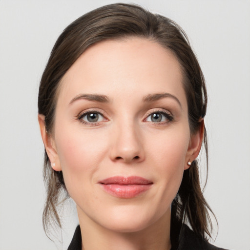 Joyful white young-adult female with medium  brown hair and grey eyes