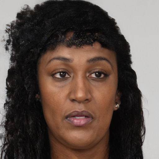 Joyful black young-adult female with long  black hair and brown eyes
