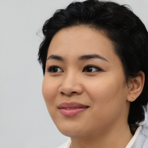 Joyful asian young-adult female with medium  black hair and brown eyes