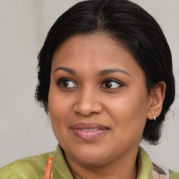 Joyful black adult female with medium  brown hair and brown eyes