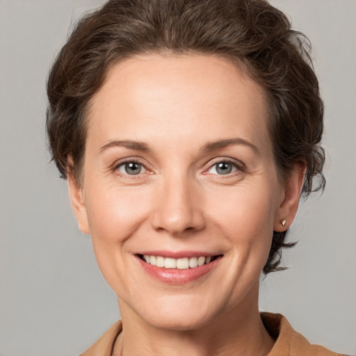 Joyful white adult female with short  brown hair and grey eyes