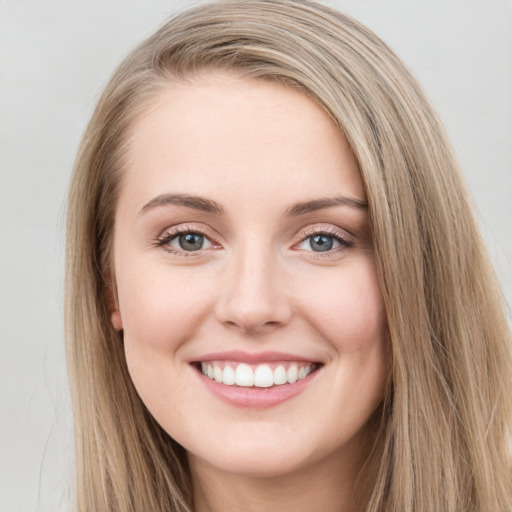 Joyful white young-adult female with long  brown hair and green eyes