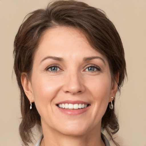 Joyful white adult female with medium  brown hair and brown eyes