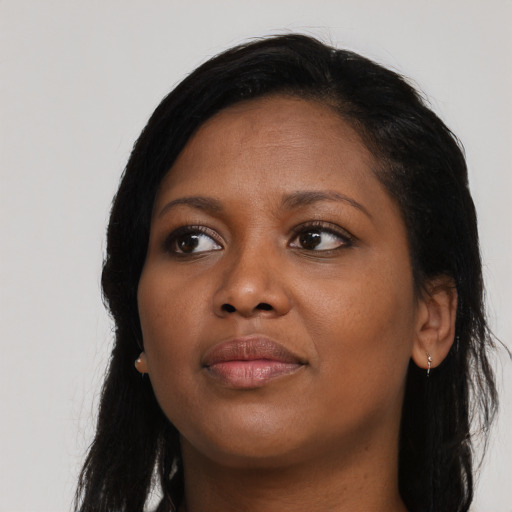Joyful black young-adult female with long  black hair and brown eyes