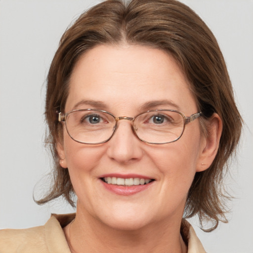 Joyful white adult female with medium  brown hair and grey eyes