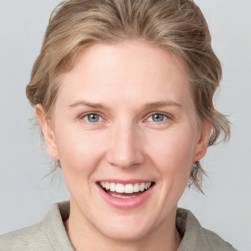 Joyful white young-adult female with medium  brown hair and blue eyes