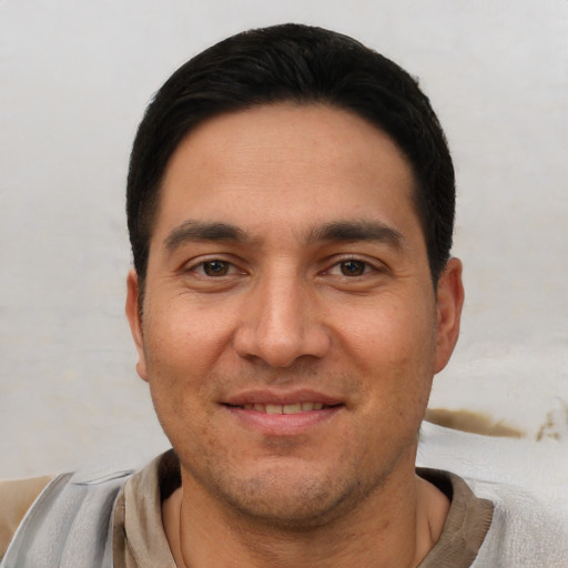 Joyful white young-adult male with short  black hair and brown eyes