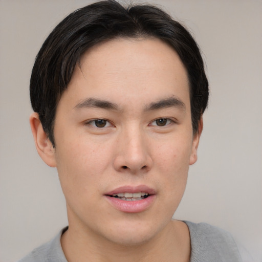 Joyful asian young-adult male with short  brown hair and brown eyes