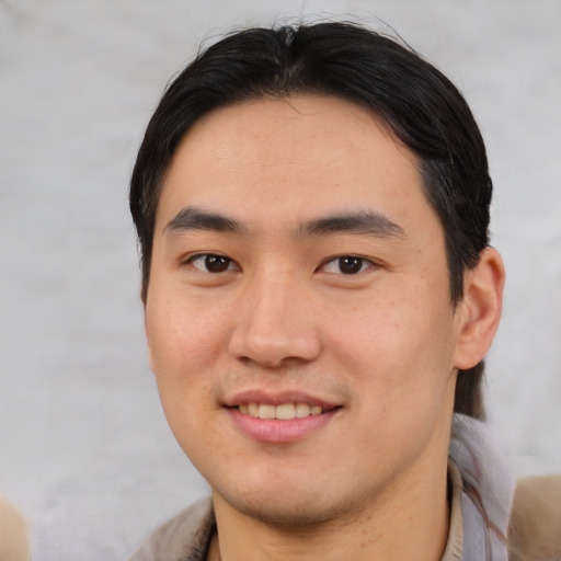 Joyful asian young-adult male with short  brown hair and brown eyes