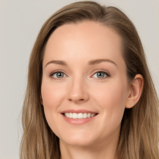 Joyful white young-adult female with long  brown hair and blue eyes