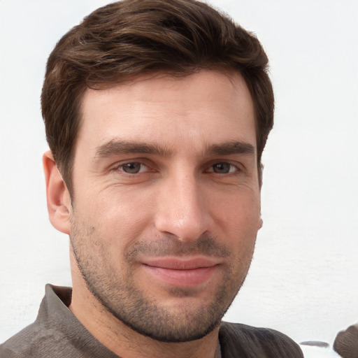 Joyful white young-adult male with short  brown hair and grey eyes