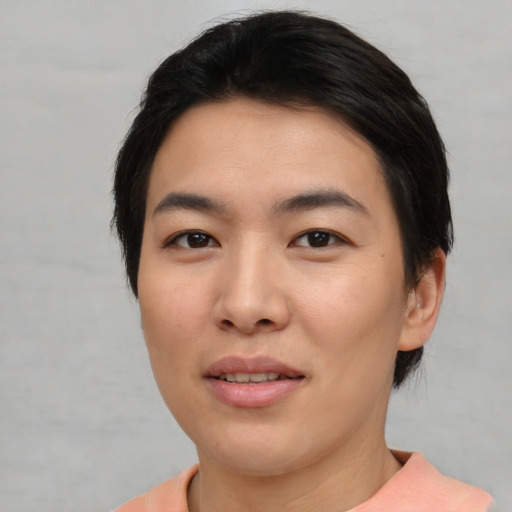 Joyful asian young-adult female with short  black hair and brown eyes