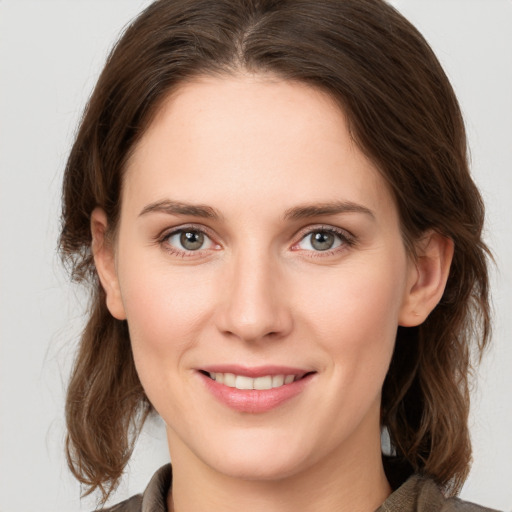 Joyful white young-adult female with medium  brown hair and grey eyes