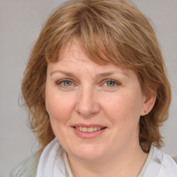 Joyful white adult female with medium  brown hair and blue eyes