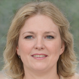 Joyful white adult female with medium  brown hair and blue eyes