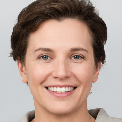 Joyful white young-adult female with short  brown hair and grey eyes