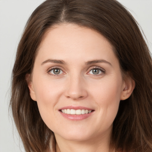 Joyful white young-adult female with long  brown hair and brown eyes