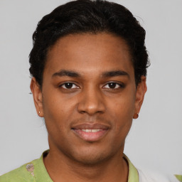 Joyful black young-adult male with short  black hair and brown eyes