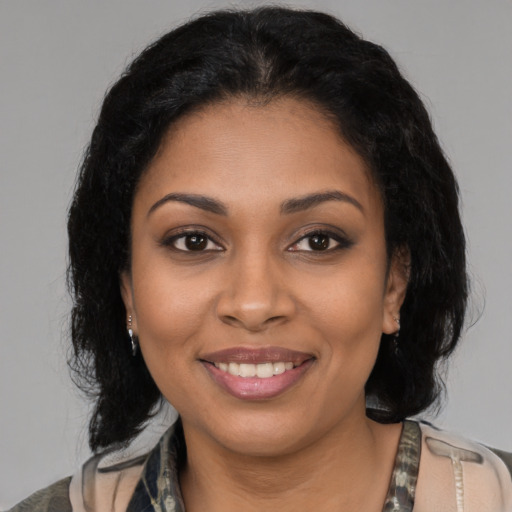 Joyful black young-adult female with medium  brown hair and brown eyes