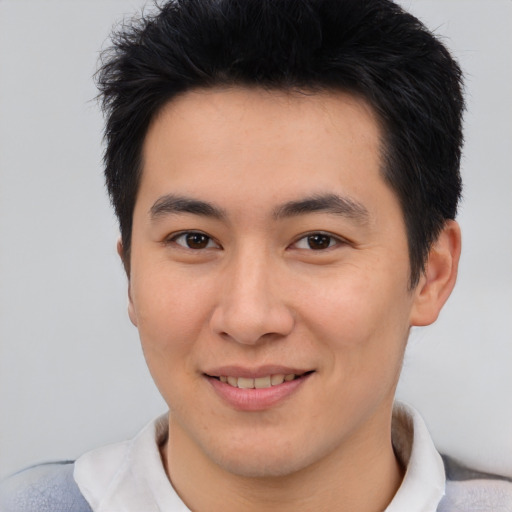 Joyful asian young-adult male with short  brown hair and brown eyes