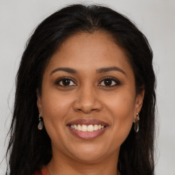 Joyful latino young-adult female with long  brown hair and brown eyes