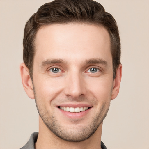 Joyful white young-adult male with short  brown hair and grey eyes