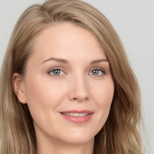 Joyful white young-adult female with long  brown hair and brown eyes