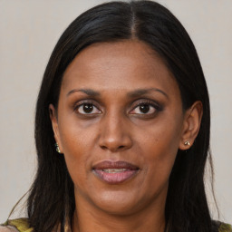 Joyful black adult female with long  brown hair and brown eyes