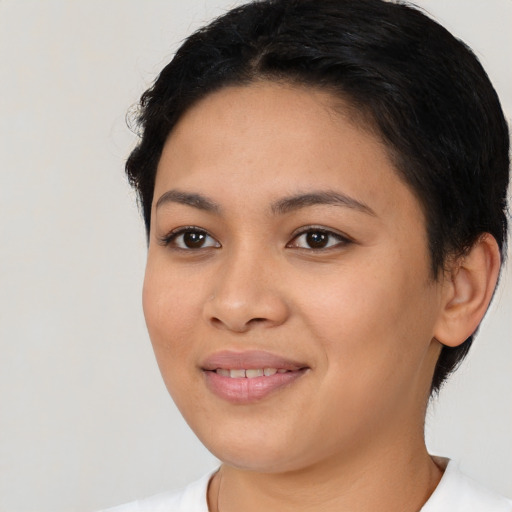 Joyful latino young-adult female with short  black hair and brown eyes