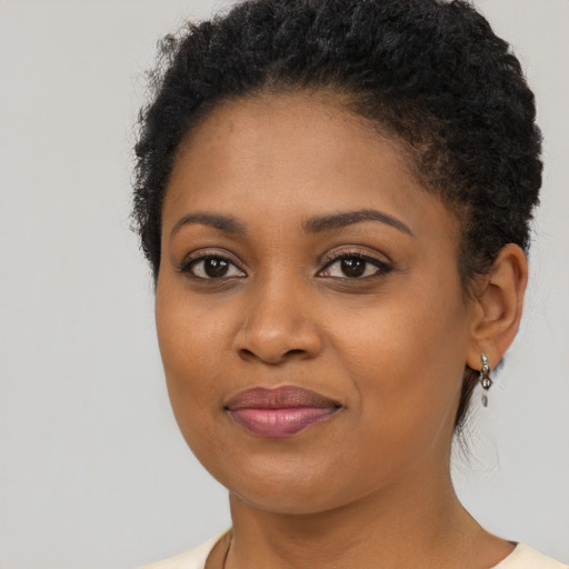 Joyful black young-adult female with short  brown hair and brown eyes