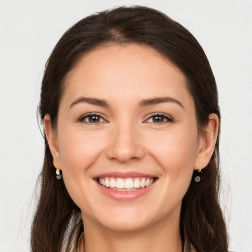 Joyful white young-adult female with long  brown hair and brown eyes