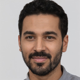 Joyful latino young-adult male with short  black hair and brown eyes