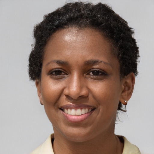 Joyful black adult female with short  brown hair and brown eyes