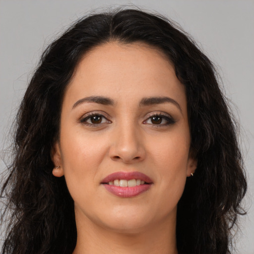 Joyful latino young-adult female with long  brown hair and brown eyes