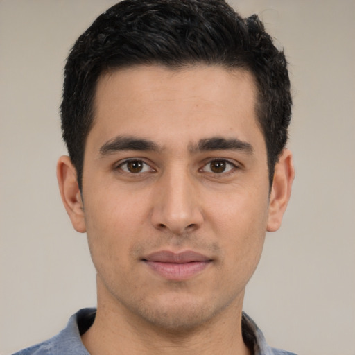 Joyful latino young-adult male with short  black hair and brown eyes