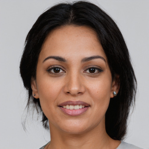 Joyful latino young-adult female with medium  brown hair and brown eyes